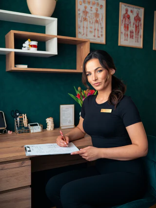 Brand portrait of a professional writing notes at a desk in a consulting room
