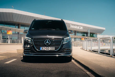 Fekete Mercedes kisbusz a Liszt Ferenc Repülőtér Terminal 2A épülete előtt.