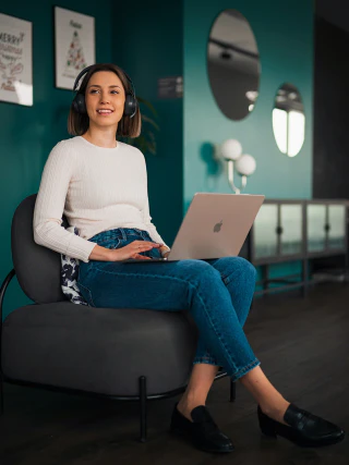 Portrait of a young woman sitting in a modern interior with a laptop in her hands