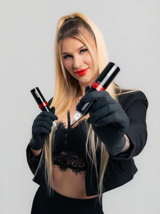 Blonde business owner holding two products in front of a bright studio background