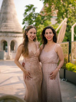 Two women wearing elegant sparkling dresses standing together in Budapest