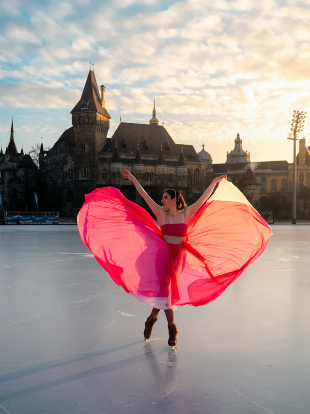 A woman ice skating in a bright pink tulle skirt against an urban background