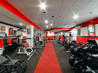 Jól felszerelt edzőterem súlyzókkal és fitneszgépekkel