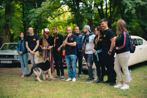 Résztvevők gyülekeznek egy szabadtéri autós rendezvényen.