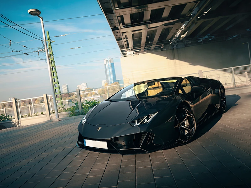 Black Lamborghini Huracán Spyder beneath a flyover.