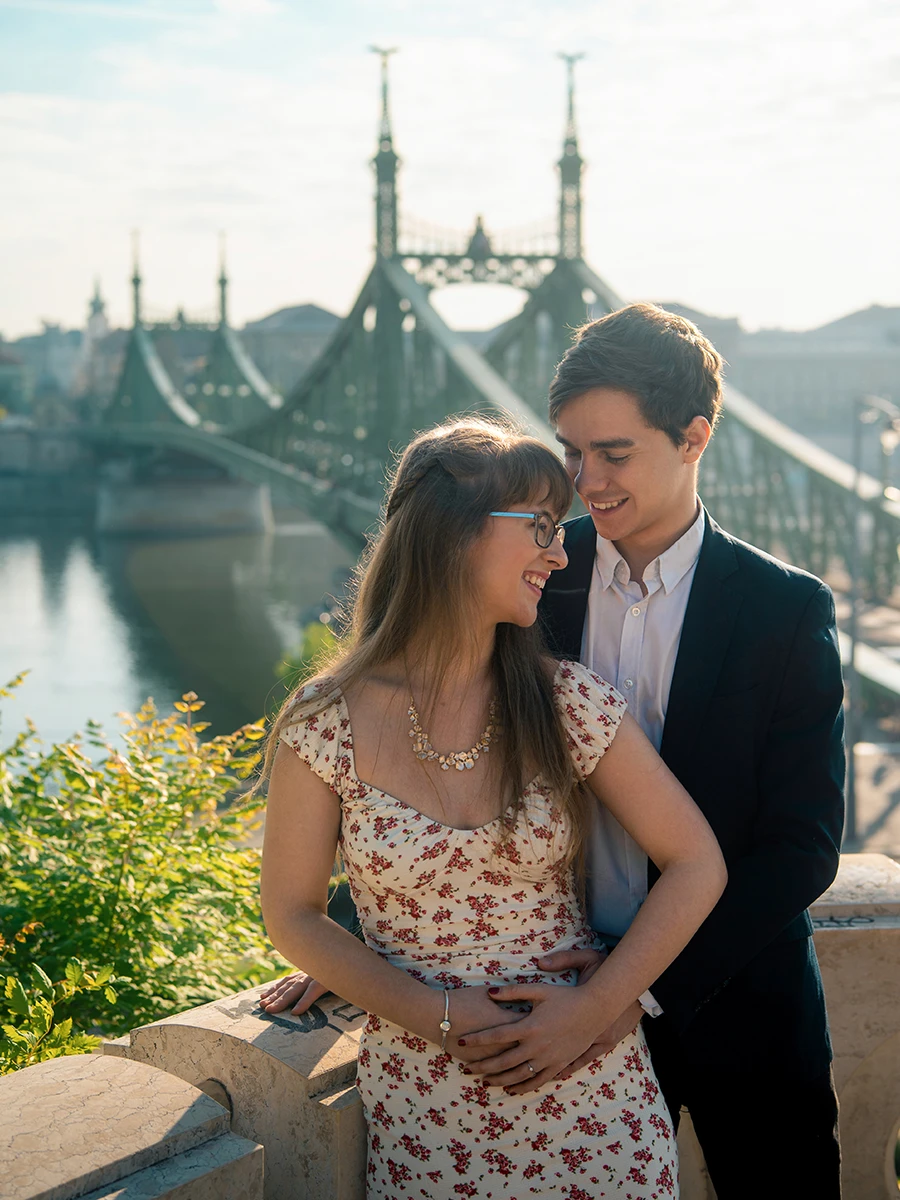 A couple embracing above Budapest with Liberty Bridge behind them
